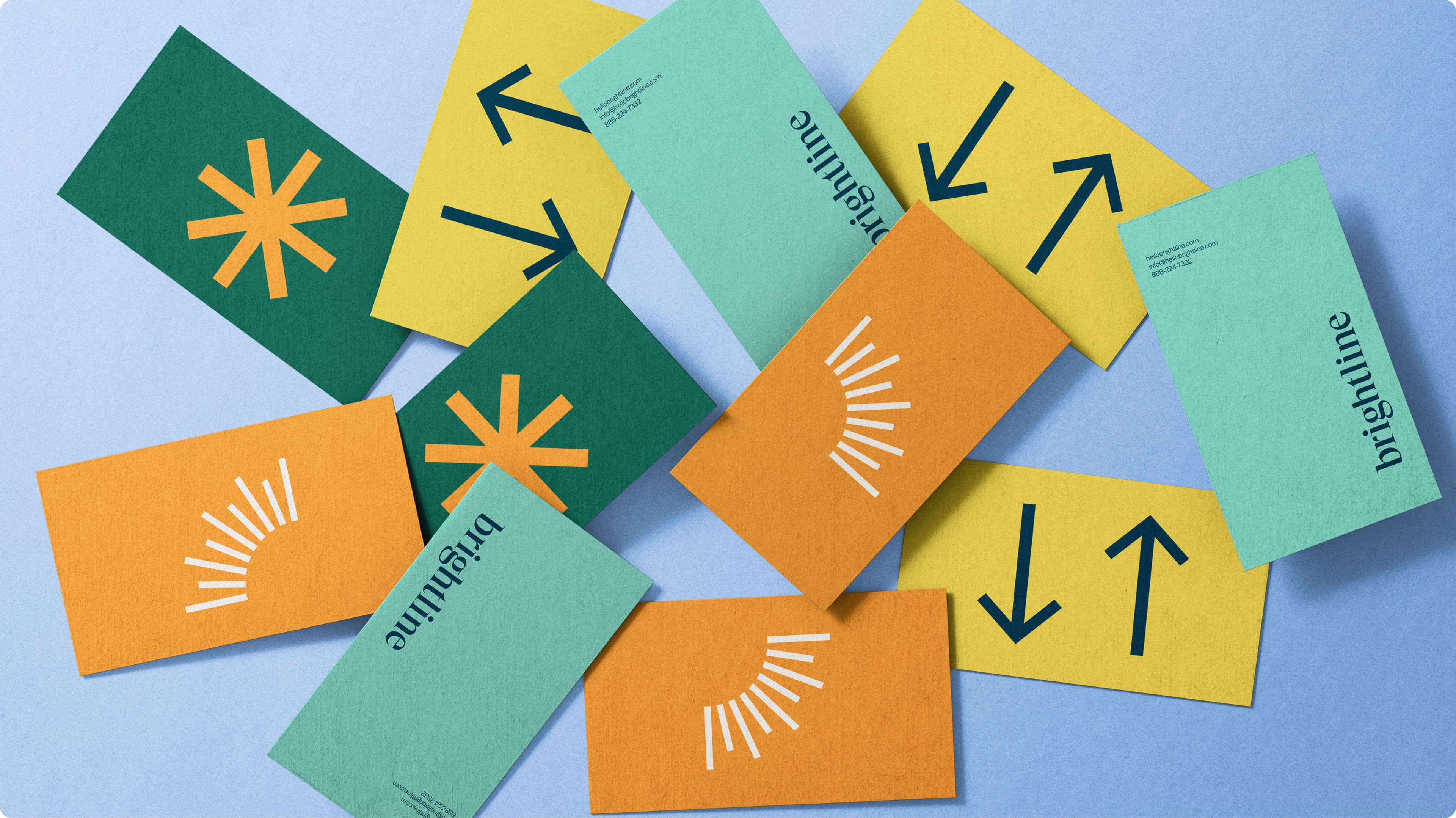 Scattered Brightline branded business cards in green, yellow, orange, and mint, featuring the "brightline" wordmark, sun/ray icons, asterisk logos, and directional arrow motifs.